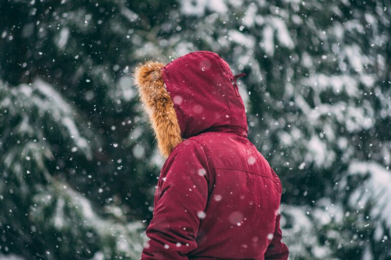 Person wearing a red insulated winter coat outdoors in the snow