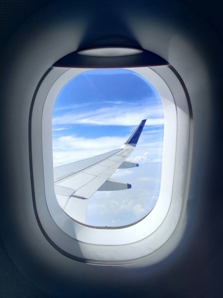 Airplane wing above clouds, representing finding the best flight deals